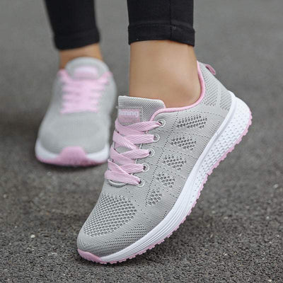 Women's lace-up running shoes in black and white, featuring a mesh design and flat heel.